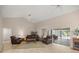 Comfortable living room boasts tile flooring, ceiling fans, and glass sliding doors to an enclosed patio at 5661 Nw 96Th Ln, Ocala, FL 34482