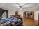 Large main bedroom with hardwood floors, a ceiling fan, and a view of the backyard at 5661 Nw 96Th Ln, Ocala, FL 34482