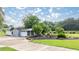 View of outbuilding with grey siding, white trim, and tidy landscaping at 5661 Nw 96Th Ln, Ocala, FL 34482