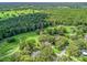 Beautiful aerial view of a golf course community and home with mature trees and landscaping at 5714 Nw 80Th Avenue Rd, Ocala, FL 34482