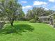 Lush backyard featuring a well-maintained lawn, mature trees, and screened pool area at 5714 Nw 80Th Avenue Rd, Ocala, FL 34482