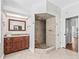 Bright bathroom features a granite countertop, wood cabinets, and an open shower with pebble floor and tile walls at 5714 Nw 80Th Avenue Rd, Ocala, FL 34482
