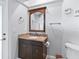 Bathroom vanity with wood cabinets, neutral countertop, undermount sink, and a round beveled mirror at 5714 Nw 80Th Avenue Rd, Ocala, FL 34482