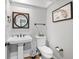 Bathroom with a pedestal sink, toilet, modern fixtures, and a Florida-themed map as decor at 5714 Nw 80Th Avenue Rd, Ocala, FL 34482