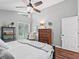 Bedroom features hardwood floors, a large bed, and natural light streaming through the window at 5714 Nw 80Th Avenue Rd, Ocala, FL 34482