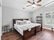 Cozy bedroom featuring hardwood floors, ceiling fan, and a large bed with plush pillows at 5714 Nw 80Th Avenue Rd, Ocala, FL 34482