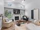 Inviting living room features high ceilings, wood floors, a fireplace, and natural light from large windows at 5714 Nw 80Th Avenue Rd, Ocala, FL 34482