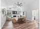 Inviting living room features high ceilings, wood floors, a fireplace, and natural light from large windows at 5714 Nw 80Th Avenue Rd, Ocala, FL 34482