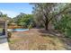 Expansive backyard with a pool, mature trees, outdoor seating, and storage shed at 6060 Se 119Th Pl, Belleview, FL 34420