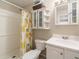Bathroom with a tub-shower combo, charming lemon shower curtain, and ample storage space at 6060 Se 119Th Pl, Belleview, FL 34420