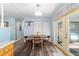 Charming dining area with wood flooring, light blue walls, and access to the screened-in patio and pool at 6060 Se 119Th Pl, Belleview, FL 34420