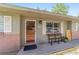 Inviting front porch with decorative wreath, outdoor seating, and a view of the front yard at 6060 Se 119Th Pl, Belleview, FL 34420
