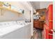 Functional laundry area features modern washer and dryer, with storage shelves at 6060 Se 119Th Pl, Belleview, FL 34420
