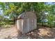 Backyard shed providing extra storage space, with a wooded backdrop at 6060 Se 119Th Pl, Belleview, FL 34420