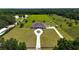 An aerial view showcases the property with a long driveway and expansive green lawns at 6160 W Highway 326, Ocala, FL 34482