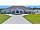 A beautiful white home with a circular driveway and lush green lawn, perfect for outdoor enjoyment at 6160 W Highway 326, Ocala, FL 34482