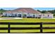 A charming single-story home with a well-manicured lawn and a quaint wooden fence at 6160 W Highway 326, Ocala, FL 34482