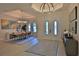 A grand foyer showcases modern lighting fixtures and front door design with a view of the dining room at 6160 W Highway 326, Ocala, FL 34482