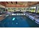 Bright indoor pool featuring dolphin art in the bottom, lounge seating, and a dining area at 6160 W Highway 326, Ocala, FL 34482