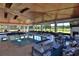 Inviting indoor pool with a stunning wooden ceiling, lounge chairs, and a cozy seating area with a fireplace at 6160 W Highway 326, Ocala, FL 34482