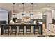 Modern kitchen featuring a spacious island with bar stools, contemporary lighting, and state-of-the-art appliances at 6160 W Highway 326, Ocala, FL 34482