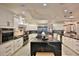The modern kitchen has sleek white cabinets, a marble island, stainless appliances, and pendant lighting at 6160 W Highway 326, Ocala, FL 34482