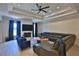 The contemporary living room features a fireplace, tray ceilings, recessed lights, and a ceiling fan at 6160 W Highway 326, Ocala, FL 34482