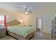 Relaxing bedroom with a comfortable bed, ceiling fan, and ample lighting from the window at 6211 Se 126Th St, Belleview, FL 34420