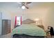 Relaxing bedroom with comfortable bed, ceiling fan, and ample lighting from bedside lamps at 6211 Se 126Th St, Belleview, FL 34420