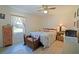 Cozy bedroom featuring a quilt-covered bed, ceiling fan, wood floors, and a window with natural light at 6211 Se 126Th St, Belleview, FL 34420