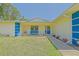 Inviting front porch with a blue door, bench, and an array of colorful potted plants at 6211 Se 126Th St, Belleview, FL 34420