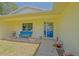 Close up of a blue door, a window, an inviting bench, and potted plants at 6211 Se 126Th St, Belleview, FL 34420