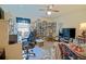Home office with desk, shelving unit, ceiling fan and TV, bathed in light from window at 6211 Se 126Th St, Belleview, FL 34420