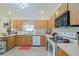 Efficient kitchen features ample oak cabinetry, white appliances, and a garden window at 6211 Se 126Th St, Belleview, FL 34420