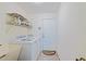 Small laundry room with wash basin, white washer and dryer, and exterior door at 6211 Se 126Th St, Belleview, FL 34420