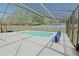 Large enclosed pool with bright blue water and pool-cleaning equipment at 6211 Se 126Th St, Belleview, FL 34420