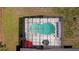 Aerial view of the screened-in pool and patio area featuring a red umbrella and outdoor seating at 6211 Se 126Th St, Belleview, FL 34420