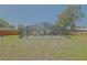 An enclosed pool with a screened cage sits amongst a large grassy yard, ready for backyard fun at 6211 Se 126Th St, Belleview, FL 34420