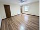 This bedroom has light-colored walls, a ceiling fan, wood-look floors and a window for natural light at 70 Almond Pass Dr, Ocala, FL 34472