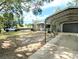 Exterior view of the home showing the covered parking area, fenced backyard and mature trees at 70 Almond Pass Dr, Ocala, FL 34472