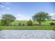 A beautiful paved patio leads to a large, green backyard and a view of a field at 7270 Sw 99Th Cir, Ocala, FL 34481