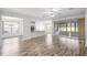 The open floorplan showcases a bright living space with hard floors connecting kitchen, dining, and porch areas at 7270 Sw 99Th Cir, Ocala, FL 34481