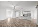 Open living space showing hard floors, a ceiling fan, and views of kitchen, porch, and entry at 7270 Sw 99Th Cir, Ocala, FL 34481