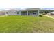 Expansive backyard with well-maintained lawn, covered patio, and exterior view of the home at 7536 Sw 60Th St, Ocala, FL 34476