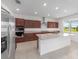 Bright kitchen featuring dark cabinets, granite countertops, a large island, and stainless steel appliances at 7536 Sw 60Th St, Ocala, FL 34476