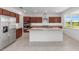 Kitchen features dark cabinets, granite countertops, a large island, and stainless steel appliances at 7536 Sw 60Th St, Ocala, FL 34476
