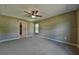 Carpeted bedroom featuring a ceiling fan, neutral walls, a window and interior door at 8040 Sw 131St Ln, Ocala, FL 34473
