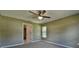 Carpeted bedroom with ceiling fan, neutral walls and trim, and a window for natural light at 8040 Sw 131St Ln, Ocala, FL 34473