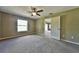 Carpeted bedroom with ceiling fan and neutral walls, features a window and interior door at 8040 Sw 131St Ln, Ocala, FL 34473