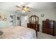 Bright bedroom with ceiling fan, dresser, and doorways to bathroom and closet at 8352 Se 168Th Trinity Pl, The Villages, FL 32162